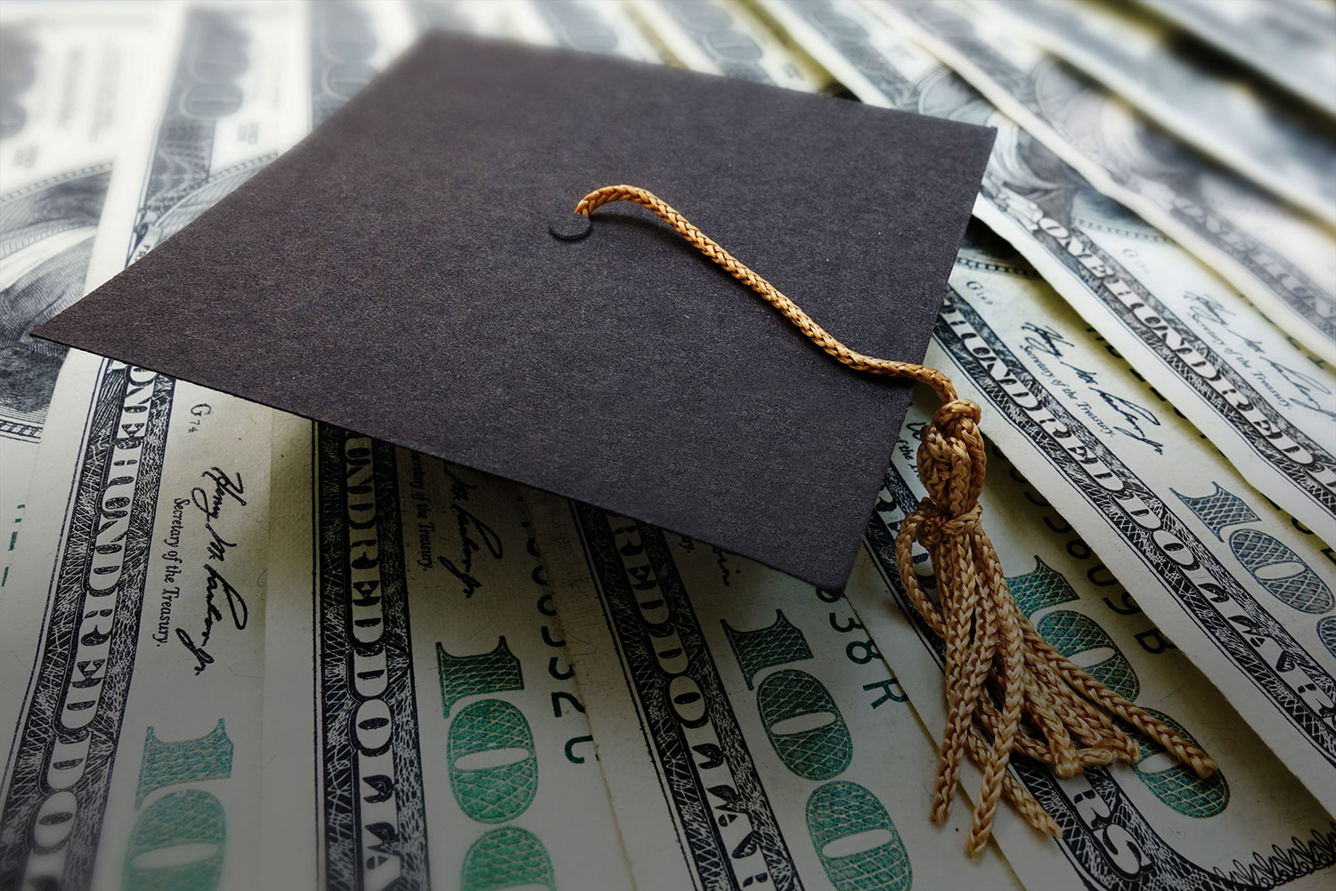 Graduation cap on background of money